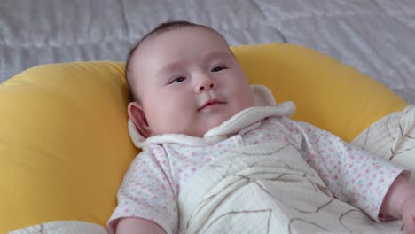 eurasian baby girl lying her back on cushion in the bedroom