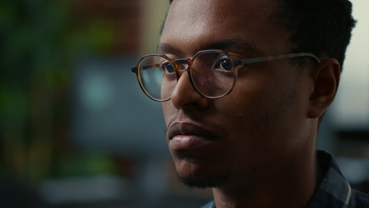 Focus on moving eyes of software developer writing code in front of monitor working focused