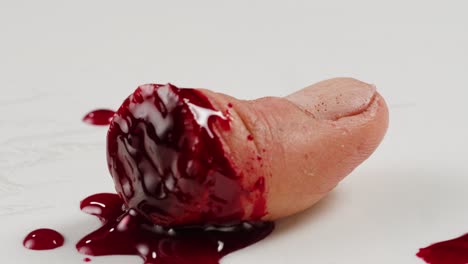 a rubber fake finger with blood close-up. make-up equipment props for films and shooting. bloody fake fingers for halloween and parties