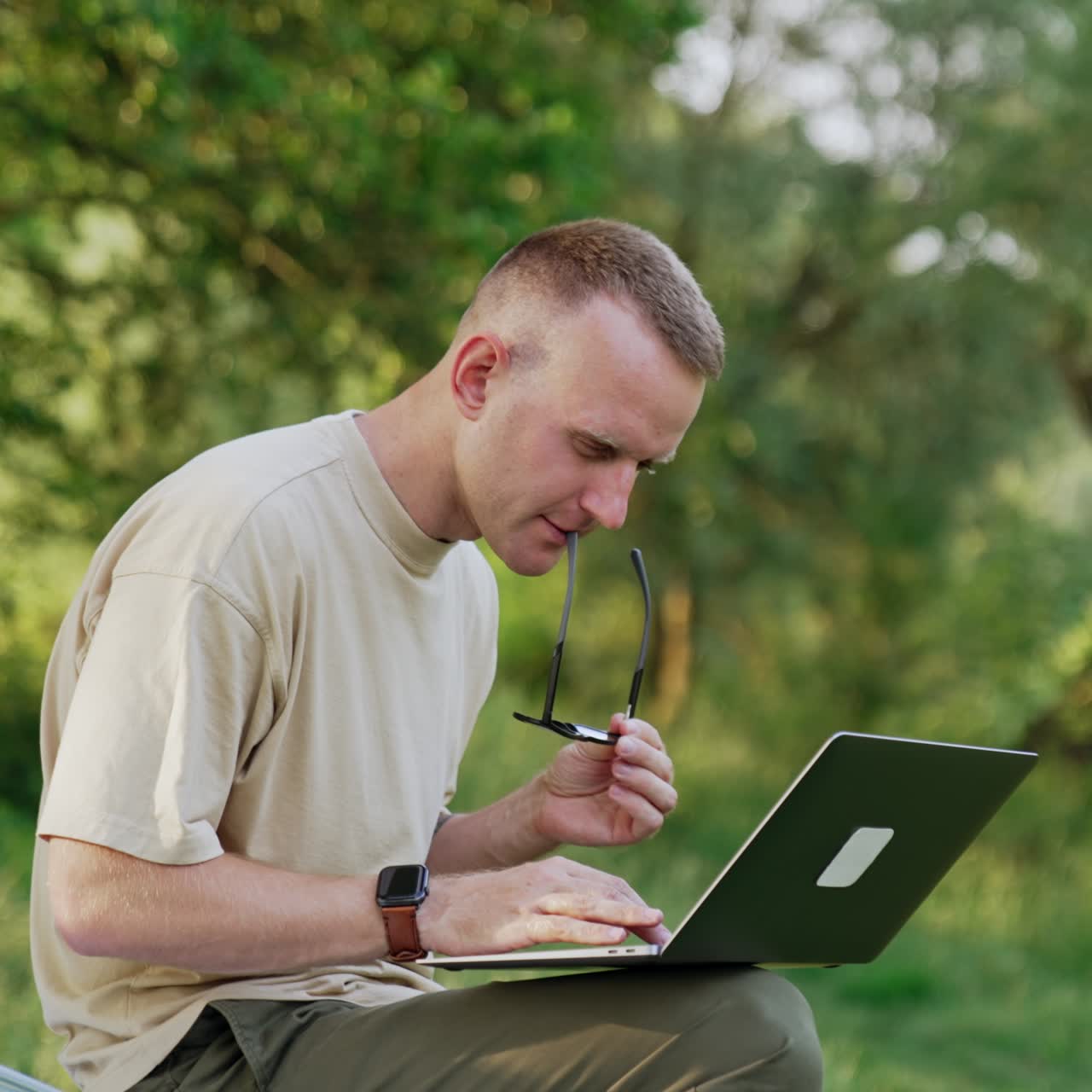 Focused Caucasian looks at his laptop screen closely. Man working remotely having some problems with work