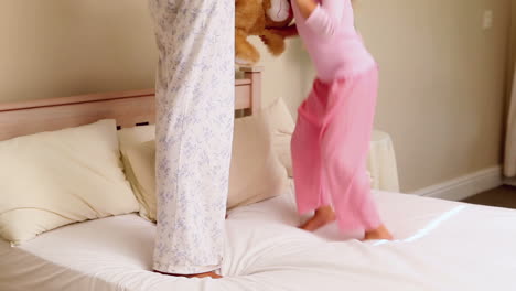 Niña-Saltando-En-La-Cama-Con-Su-Madre