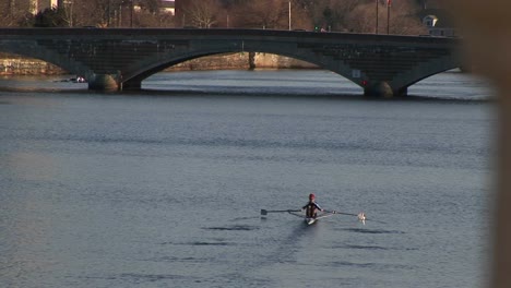 a longshot of a person sculling down the charles river