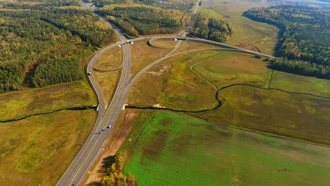 drone vista del cruce de carreteras en la carretera de campo. coches que se mueven en el cruce de carreteras