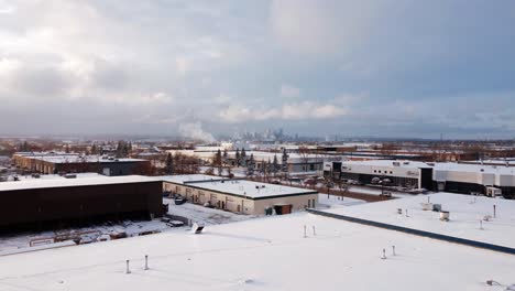 volar sobre almacenes industriales en una mañana helada de invierno en dirección al centro de calgary