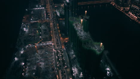 Aerial-orbiting-shot-of-residential-construction-phase-on-old-Kai-Tak-Runway-at-night---Hong-Kong