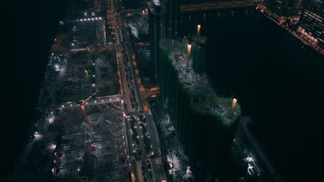 toma aérea en órbita de la fase de construcción residencial en la antigua pista de kai tak por la noche - hong kong