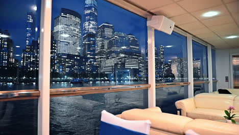 travelling on board of the cozy riverboat in the evening. luminous skyline of new york outside