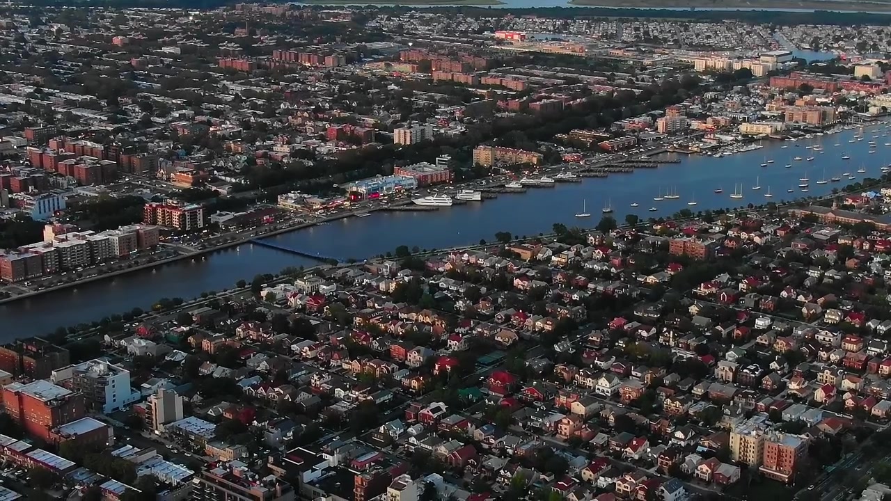 Vista da cidade de Nova Iorque com edifícios e água à noite.