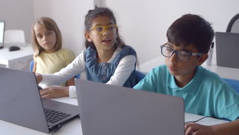 grupo de compañeros de clase usando computadoras portátiles en clase