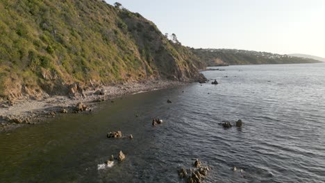 cliff beach at sunset with mountains