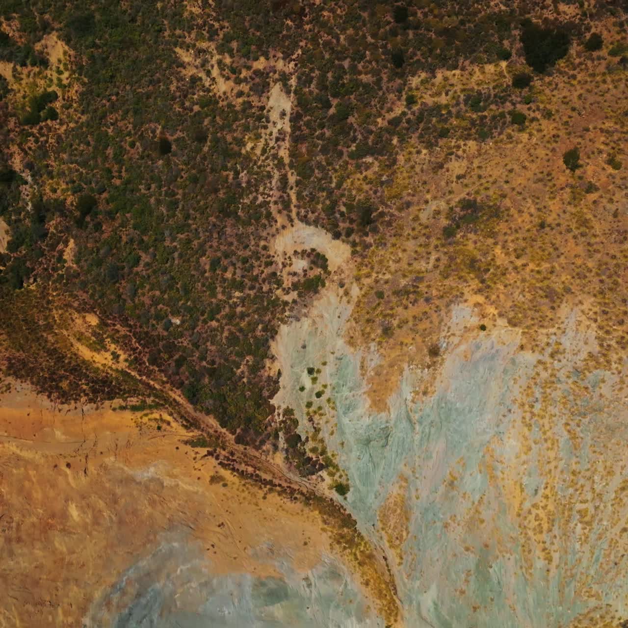 Weird dry landscape covered with moss and lichens. Motorway passing through the bare rocks of California coastline. Aerial view