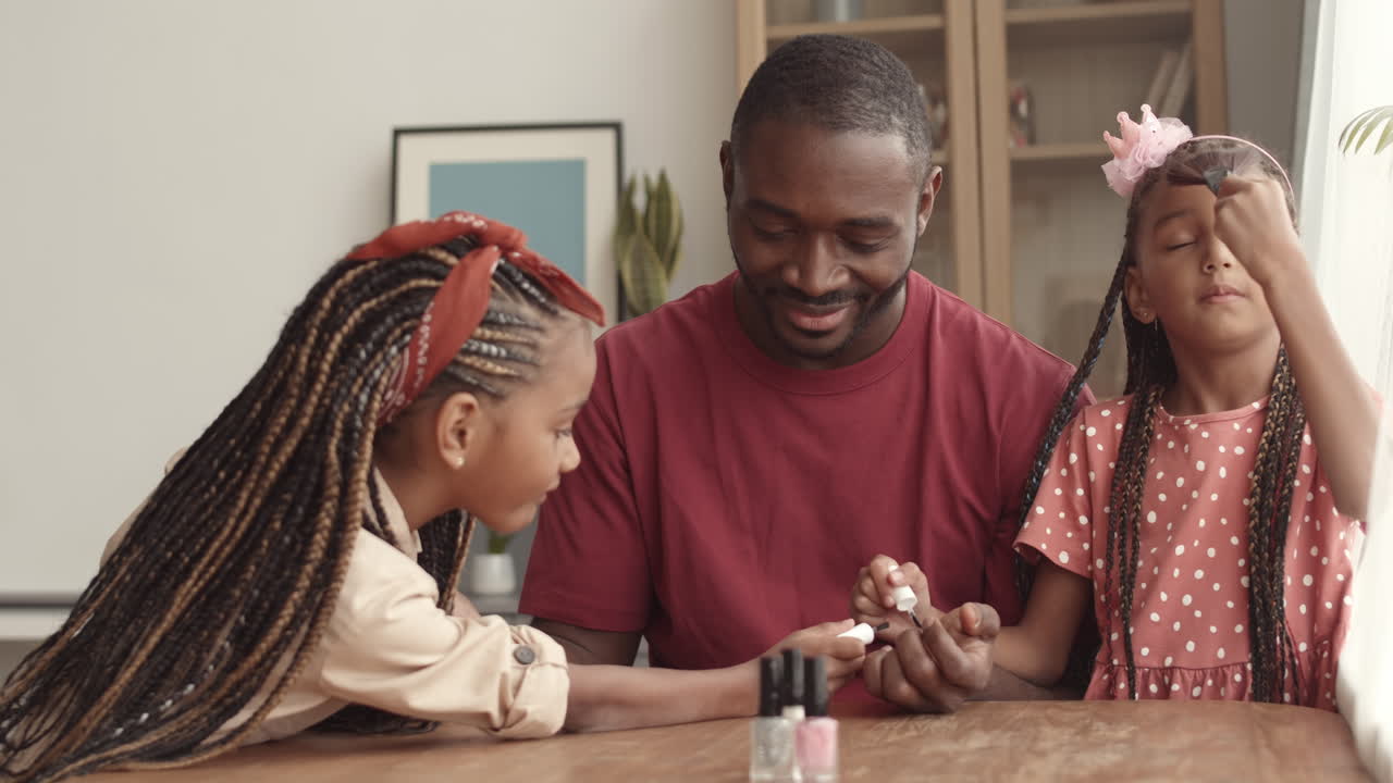 Padre che guarda le bambine giocare con il trucco