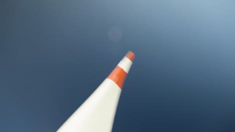 red and white wind turbine blade rotates on blue sky background, close-up