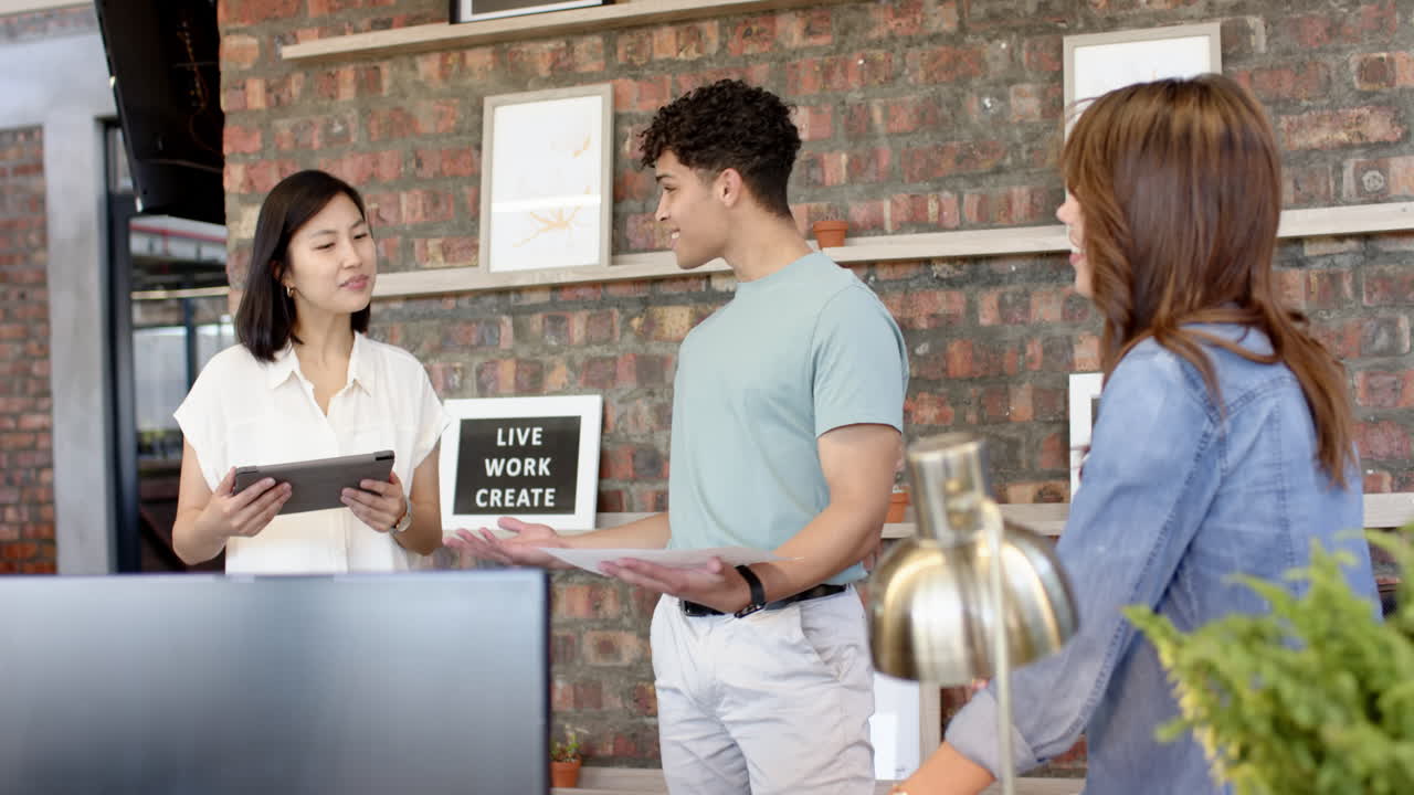 Collaborating on interior design project, multiracial team using digital tablets in modern office