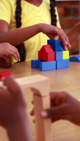 alumnos jugando con bloques de construcción en el aula