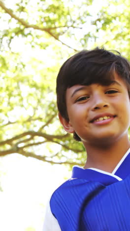 smiling boy playing a football in park