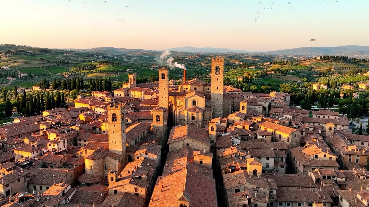 Veduta Aerea di un Borgo Storico Italiano al Tramonto: Architettura Mozzafiato Tra Colline Verdi e Lussureggianti e Tetti Incantevoli Illuminati da una Luce Dorata