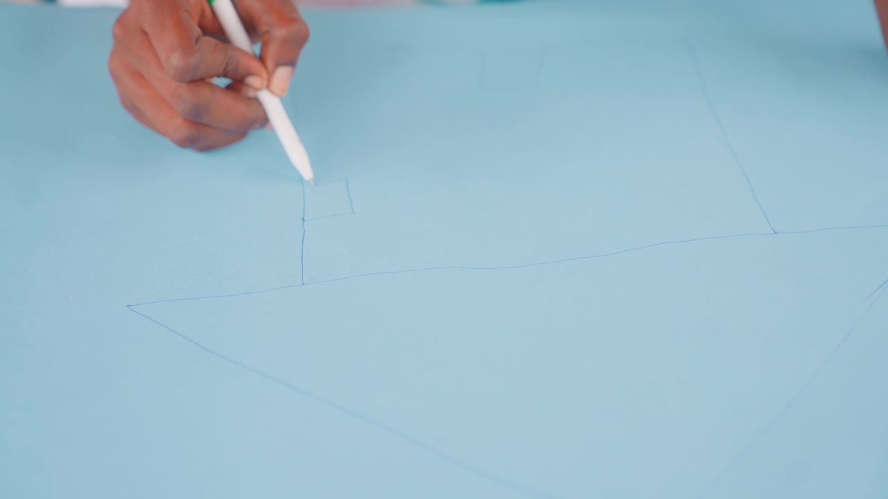 Mother designs fabric. Black mother outlines fabric design. Woman drawing precise lines on colored fabric carefully. Mother methodically marks pattern lines on blue textile for sewing project