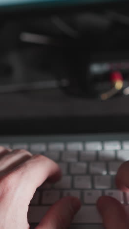 pov de un hombre escribiendo en un teclado, mirando su teléfono y planificador para la gestión del tiempo durante el trabajo