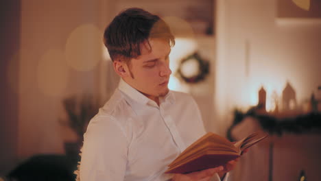 man reading book at home during christmas