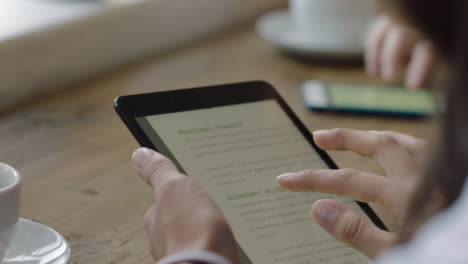 mujer de negocios joven con las manos usando una tableta en un café viendo documentos corporativos en la pantalla leyendo un proyecto financiero disfrutando de la tecnología de pantalla táctil móvil de cerca