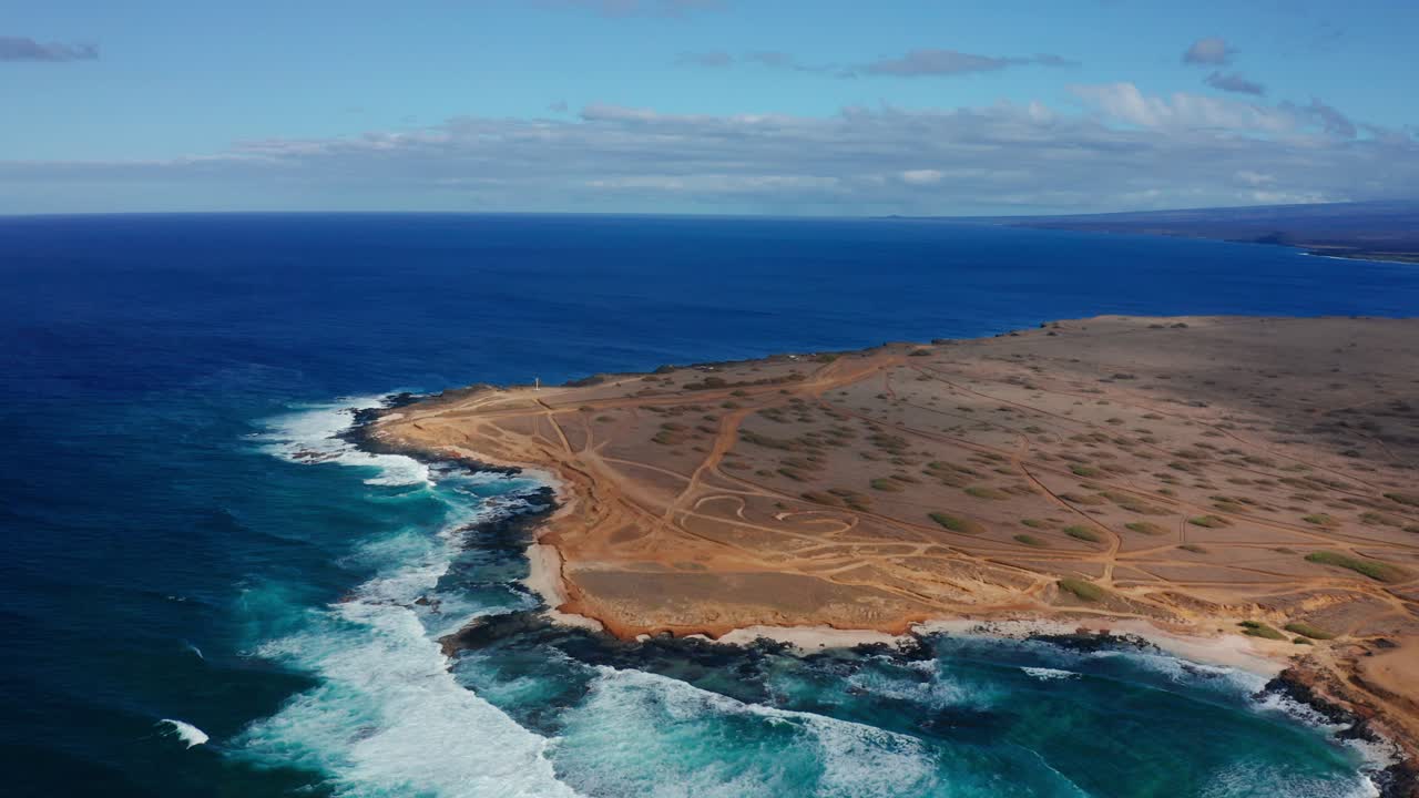 Arid desert peninsula bordered by the vibrant Pacific Ocean in Hawaii. Rugged shoreline and remote terrain create a striking natural environment.