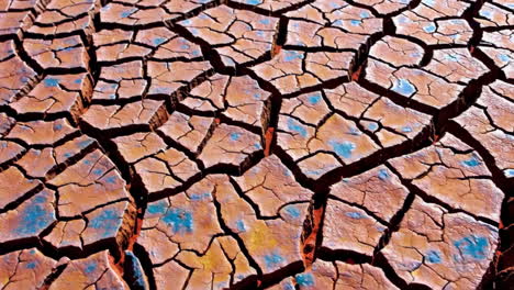 close-up of dry cracked earth with blue patches