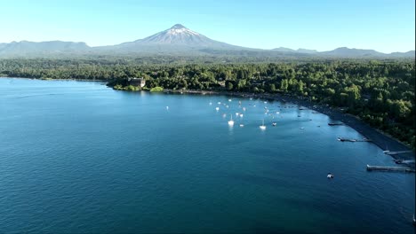 Vista-Panorámica-Aérea-Sobre-La-Bahía-Del-Lago-Villarrica-Con-Volcán-En-El-Horizonte,-Chile