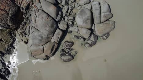 relaxed woman basking on whisky bay's rocky shore at wilsons prom in victoria, australia