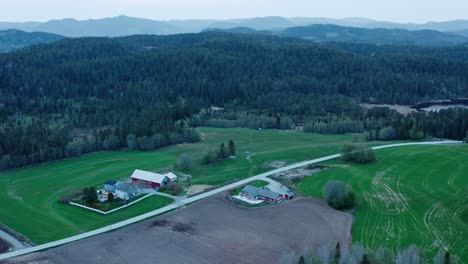 Casas-Aisladas-En-Un-Paisaje-Rural-Con-Montañas-Boscosas-Al-Fondo