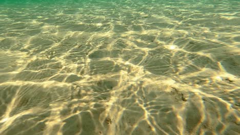 Diving-just-Above-Sand-Bottom-in-Beautiful-Clear-Turquoise-Water,-POV