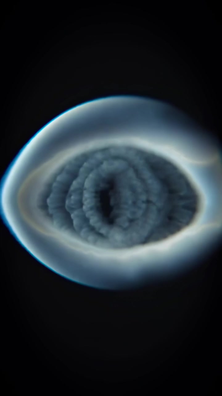 Anello di fumo bianco astratto che si dissolve in un liquido scuro