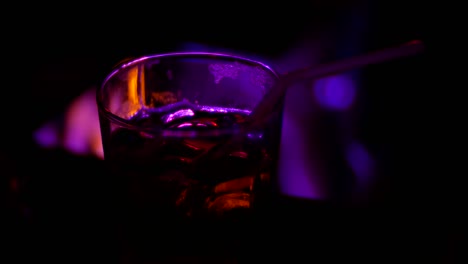 primer plano de un cóctel de alcohol en un vaso en el mostrador de un bar, en un club nocturno. fondo borroso, 4k