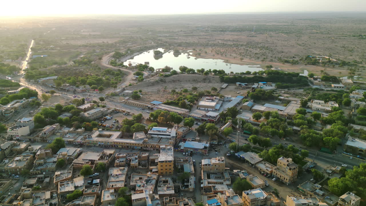 una toma de drone del lago gadsisar en jaisalmer y el paisaje urbano dorado fusionándose con el paisaje desértico de rajasthan india 4k