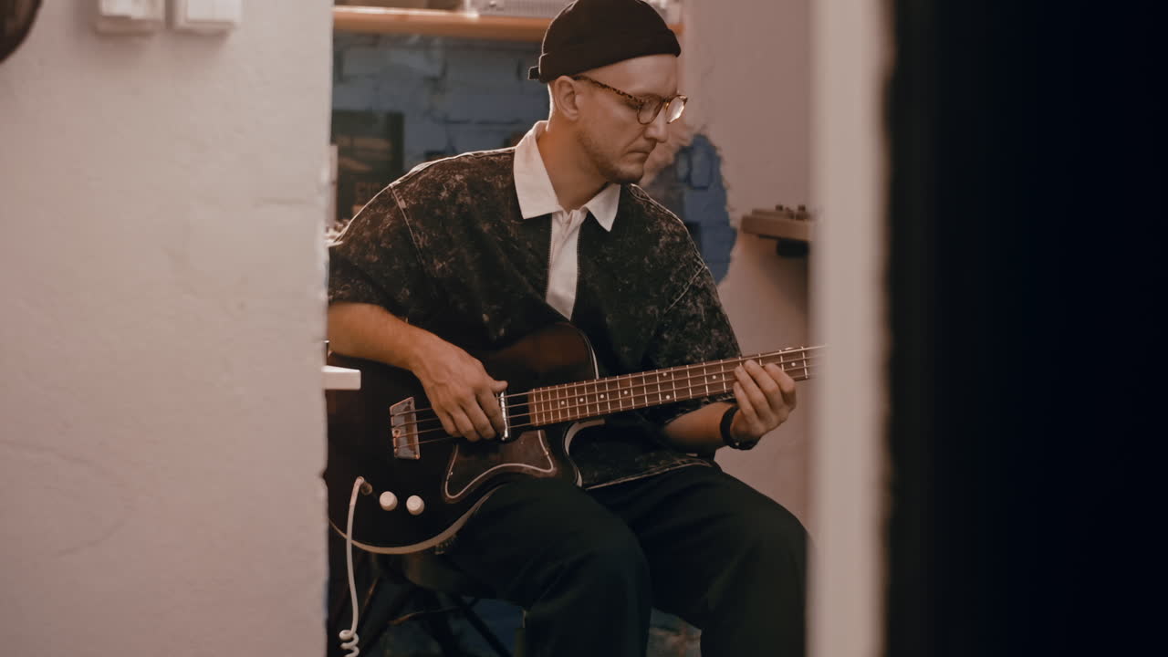Man Playing Bass Guitar in a Recording Studio