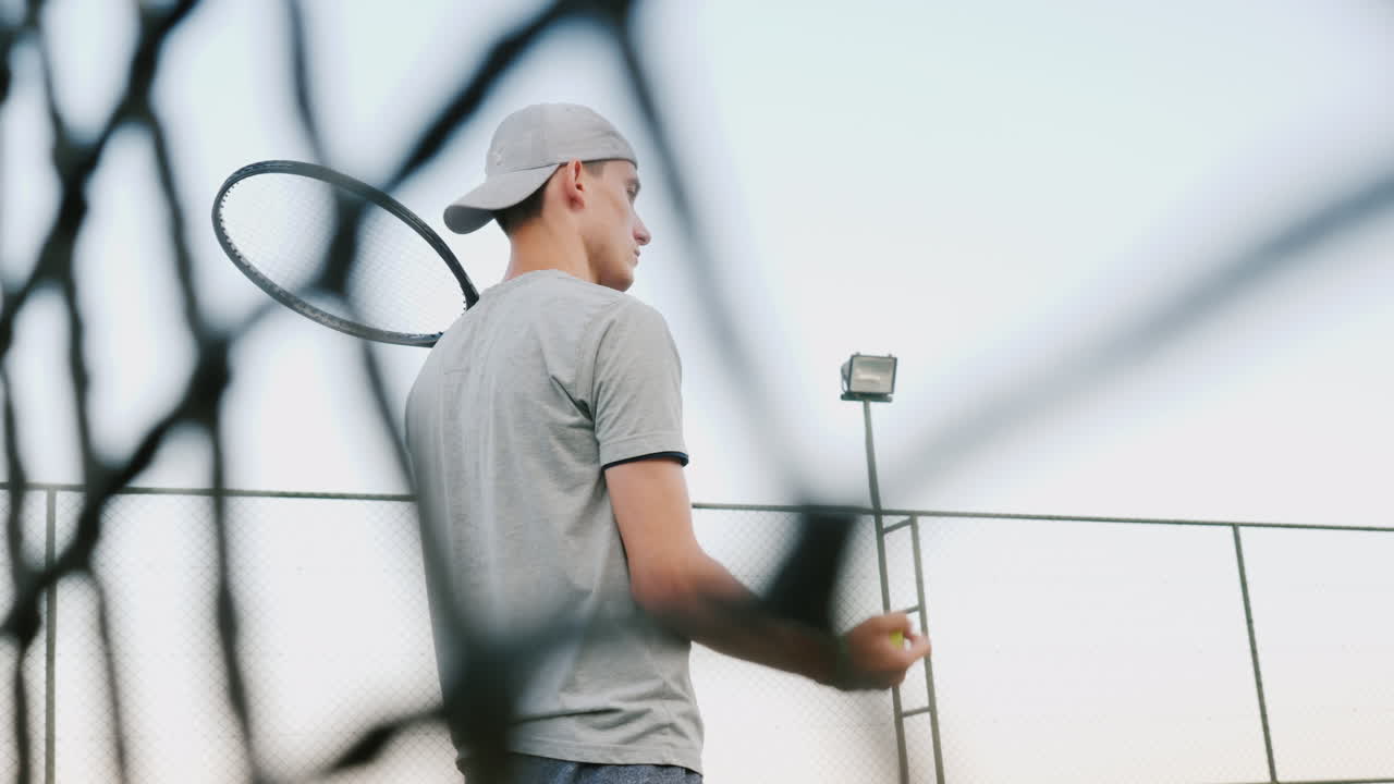 테니스 경기 전에 한 남자가 경기에 맞춰 공을 던진다