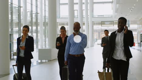 Animation of connected icons over diverse business people with phone and luggage walking at airport