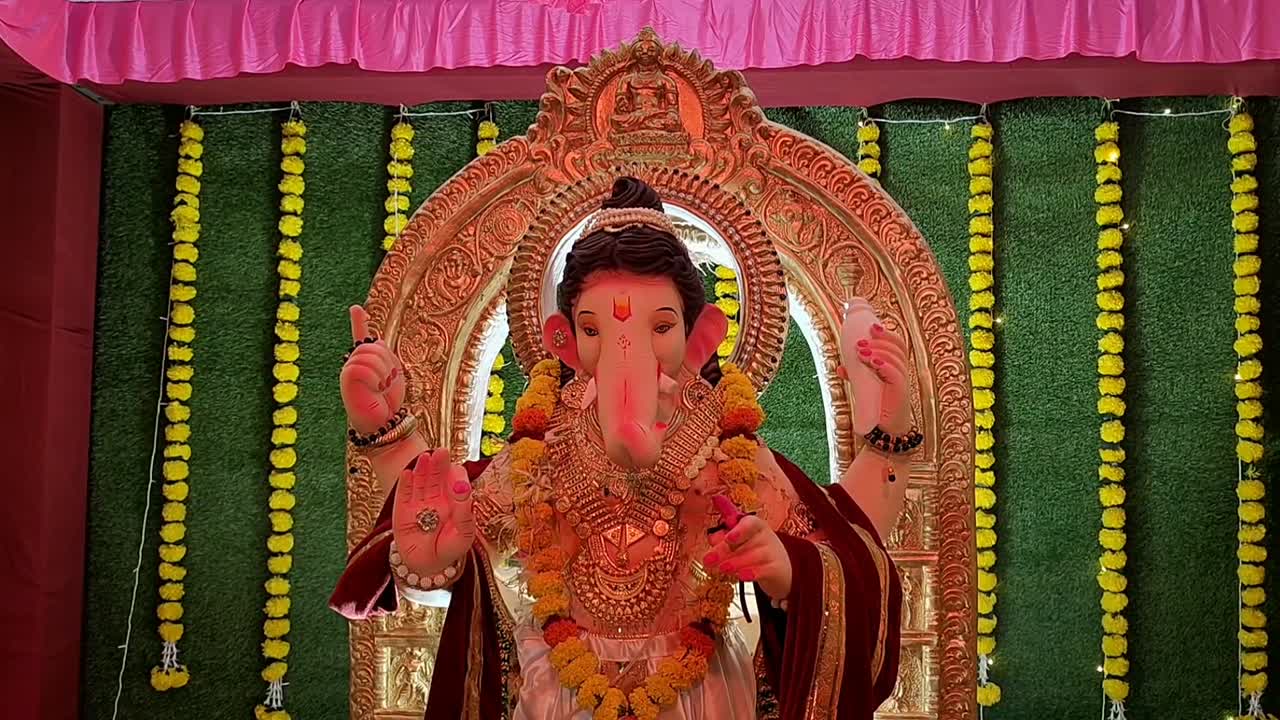 Splendida statua del Signore Ganesha in un pandal di Ganesh, illuminata drammaticamente da luce rossa durante il vivace festival di Ganesh.