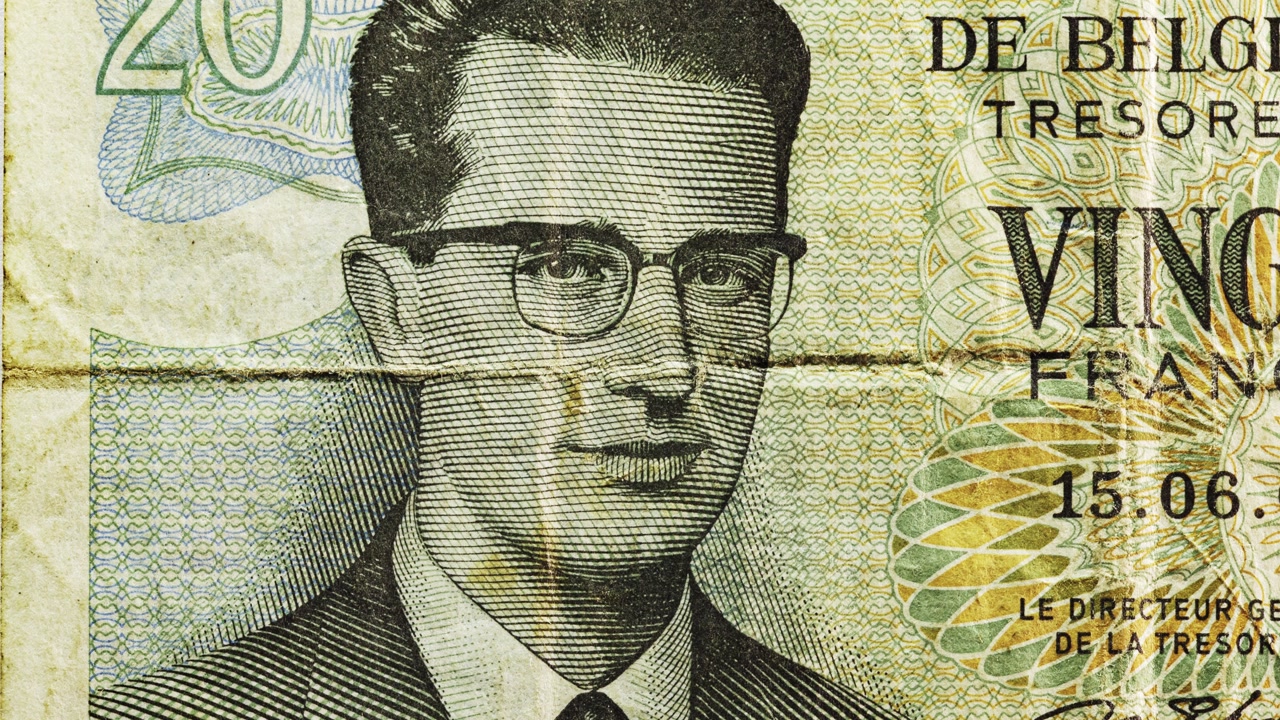 Macro pan of Belgian 20 francs note showing portrait, French text and a heavy center crease