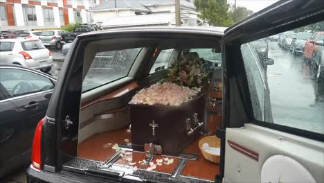 closeup shot of a funeral casket in a hearse or chapel or burial at cemetery