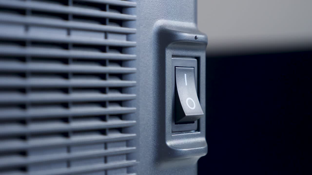 el dedo de una persona presiona se enciende y se apaga en un botón de plástico negro