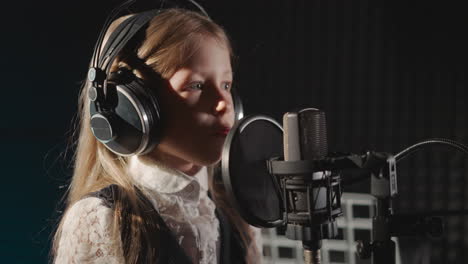 una chica joven cantando en un estudio de grabación.