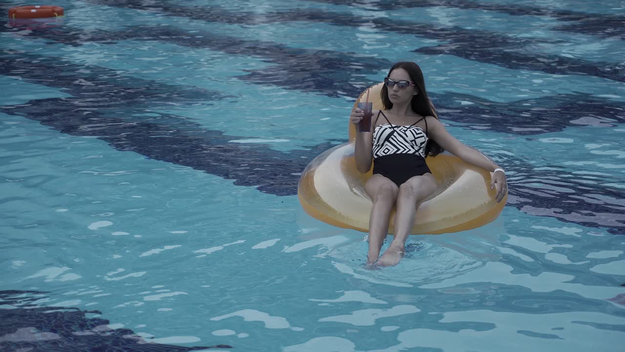 Woman Relaxing in a Pool with a Drink