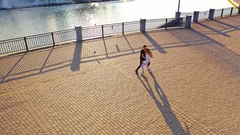 modern dancers are dancing in the street. urban lifestyle. hip-hop generation. boy's and girl's emotional moves on the video. paving stones and young dacing couple at fontain background. aerial view. young beauty dances with handsome boy.