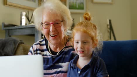 Grandmother-and-granddaughter-using-digital-tablet-in-living-room-4k