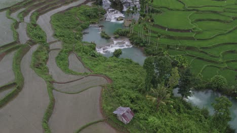 Reveal-shot-of-small-hut-next-to-the-Wee-Kacura-waterfall-at-Sumba-island,-aerial