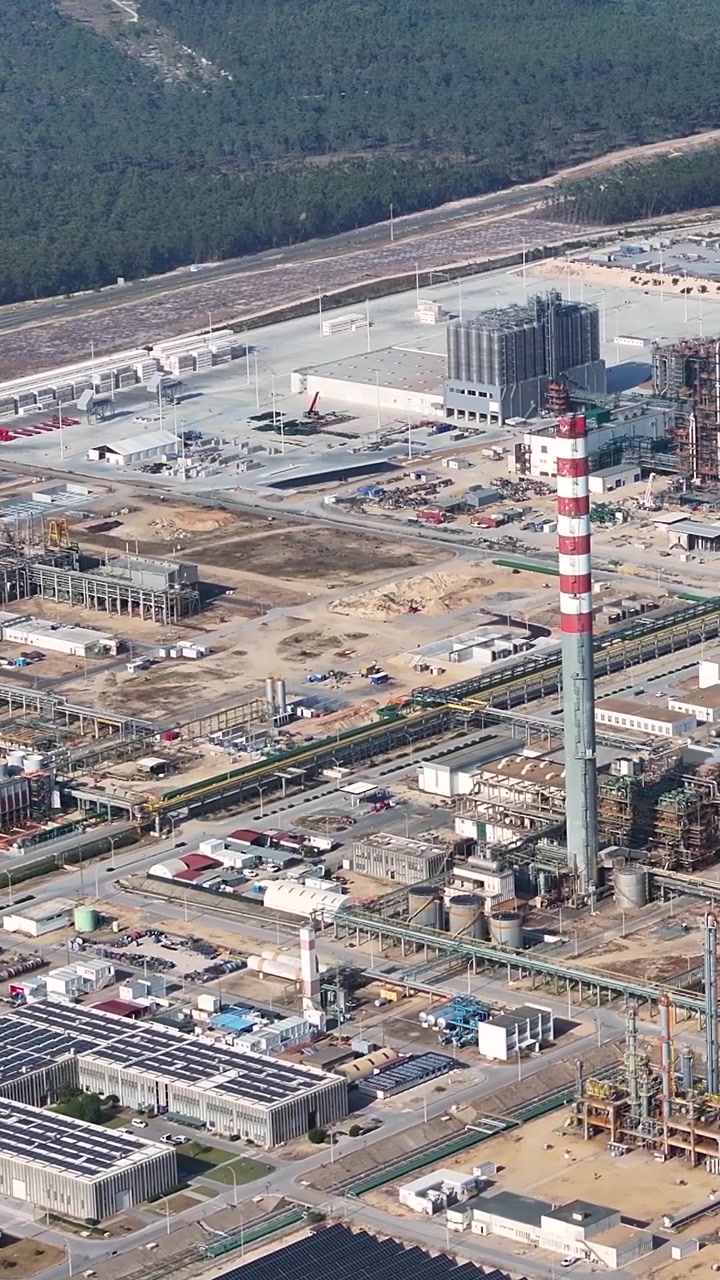 Questa clip offre una prospettiva aerea di un complesso di raffineria di petrolio che mostra varie strutture di lavorazione industriale e infrastrutture energetiche. Attrezzature e strutture sono evidenziate