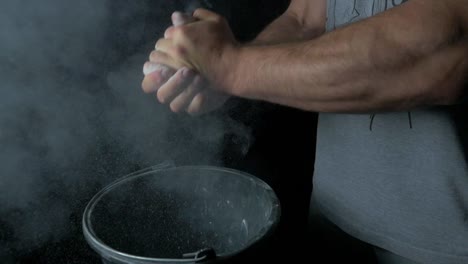 athlete applying chalk to hands