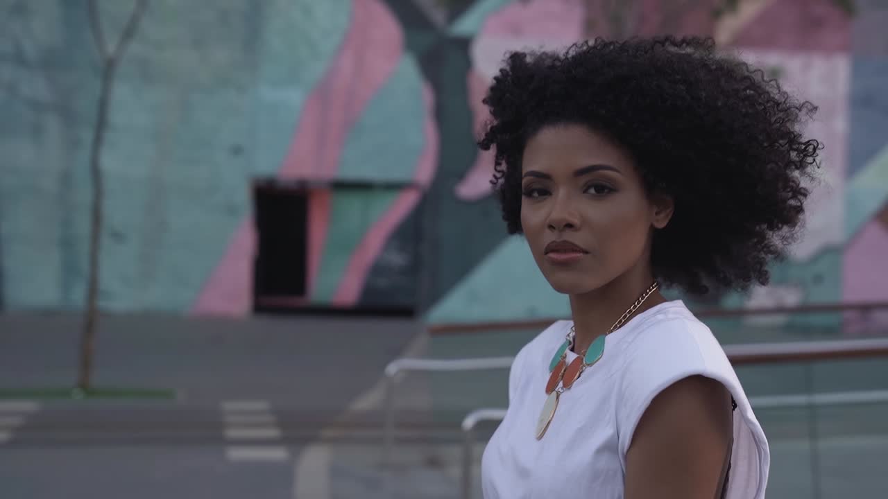 mujer afro brasileña negra caminando y haciendo contacto visual, cámara lenta, cerrar