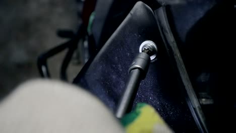 close - up of a first-person view of a metal screwdriver wrapping the bolt in black plastic motorcycle in your own garage, service